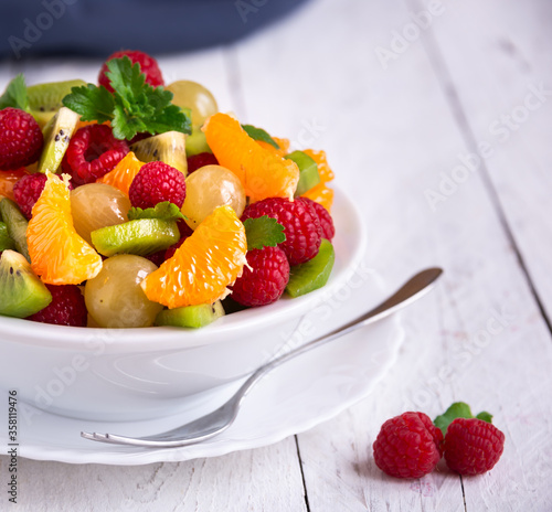 Fresh fruit salad with with raspberry, mandarin and other fruit