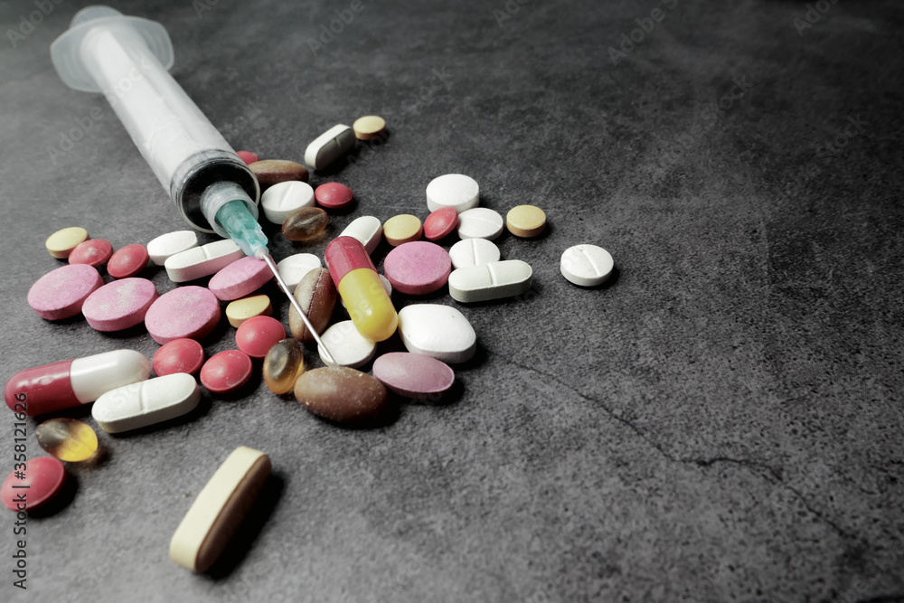 syringe and pills on dark background, close up syringe and pills on dark background, close up