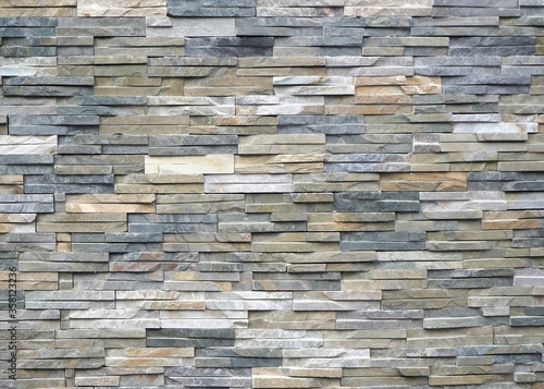 Quartzite natural stone cladding for external walls with bricks of different colors. Background and texture