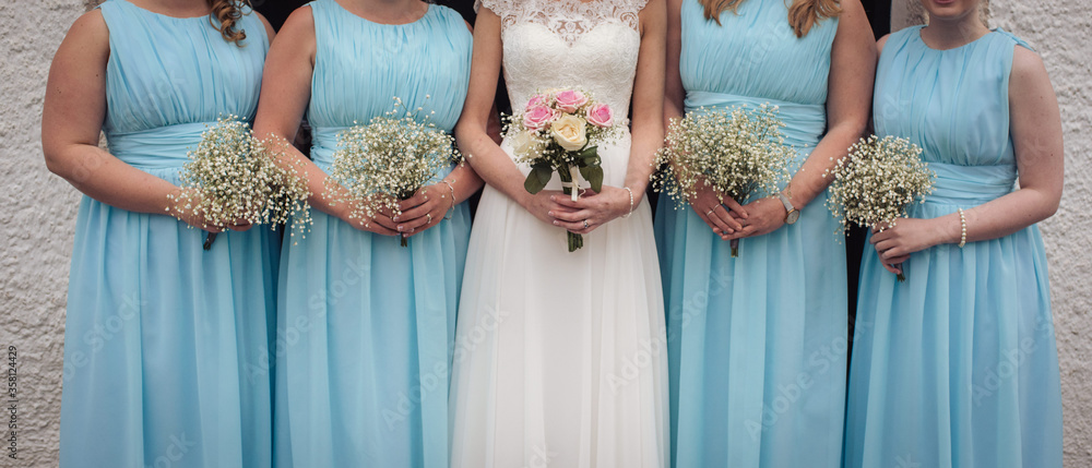 Bride and Bridesmaids in blue close up of flowers in hands