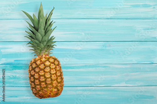 Ripe pineapple on a blue wooden background
