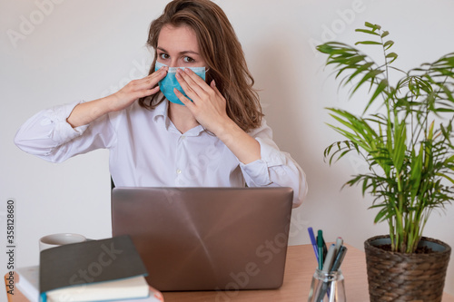 Woman in quarantine for Coronavirus wearing protective mask and smart working