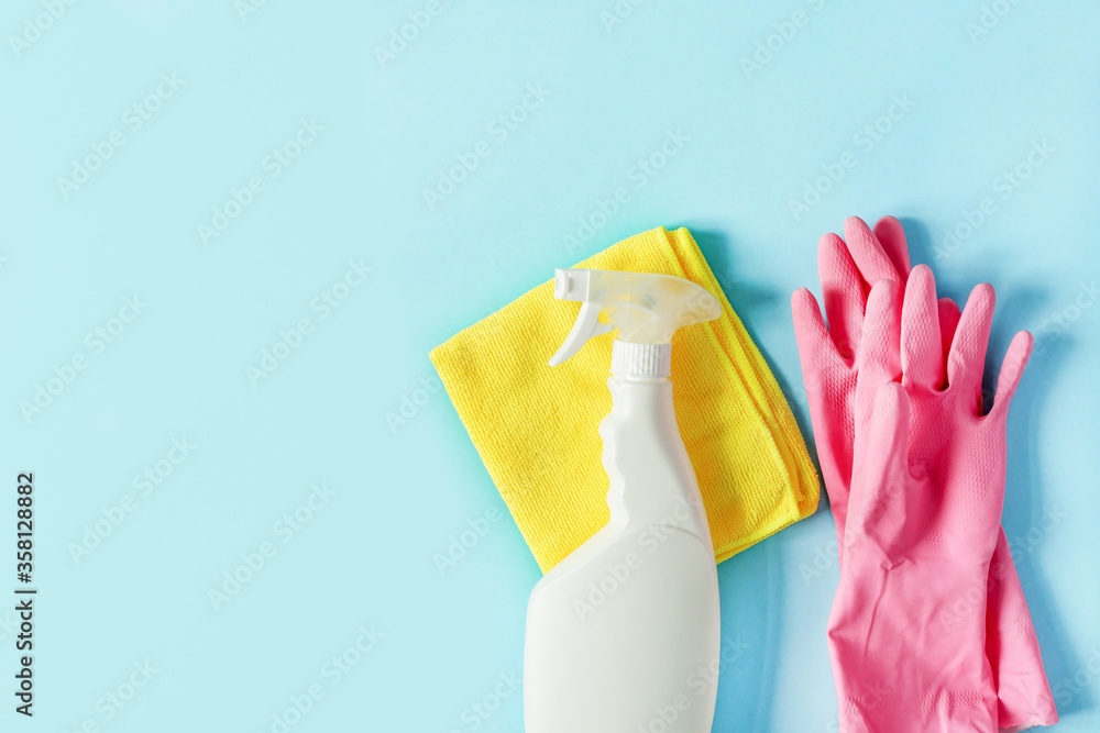 Bottle of detergent, microfiber rag and protective gloves on pastel blue background top view. Housework cleaning concept. Bottle of detergent, microfiber rag and protective gloves on pastel blue background top view. Housework cleaning concept.