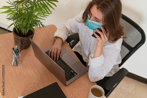 Woman in quarantine for Coronavirus wearing protective mask and smart working