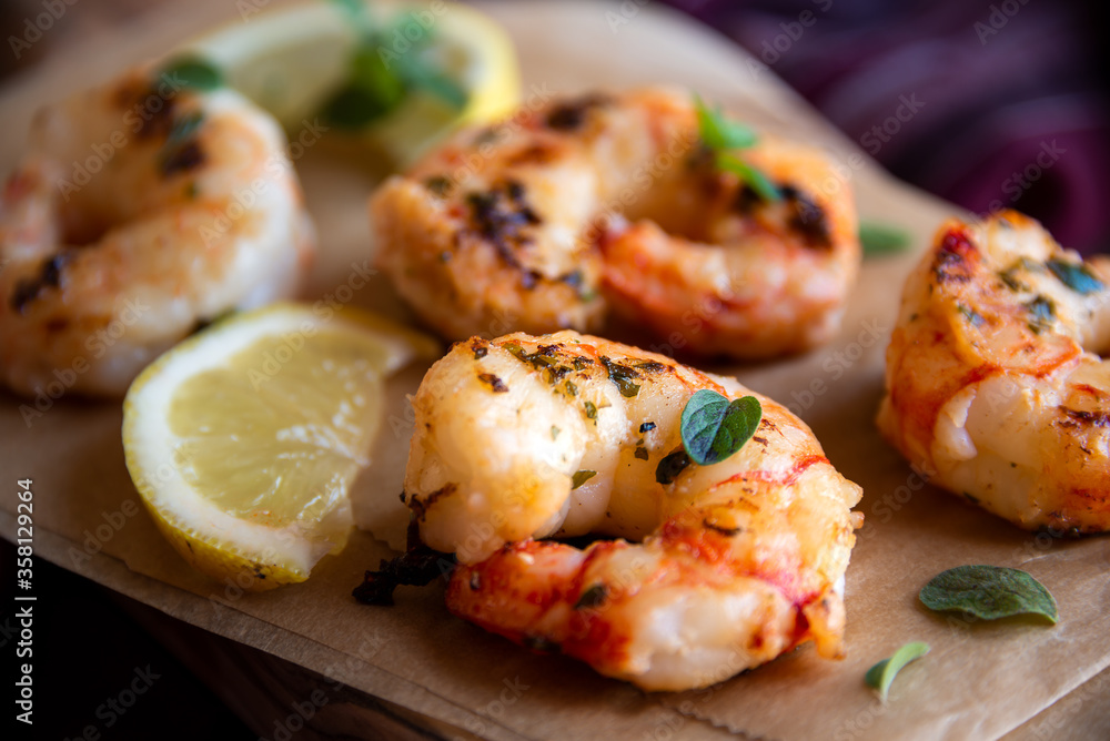 Roasted shrimps with lemon and herbs, healthy seafood meal