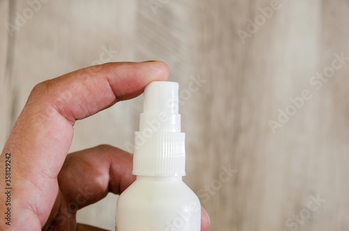 Female hands with a spray. Hand sanitizer, gel bottle disinfectant for coronavirus prevention. Close-up.