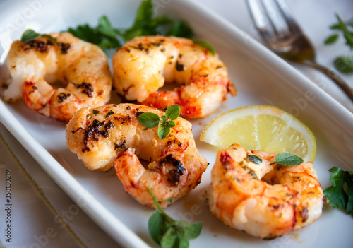 Roasted shrimps with lemon and herbs, healthy seafood meal