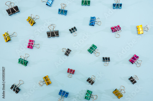 Colorful office paper clips on blue background. photo
