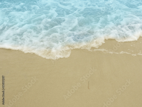 Beach sand with small ripples, vacation or travel concept background with space for text