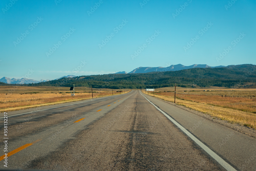 Asphalt highway receeding to vanishing point toward mountains
