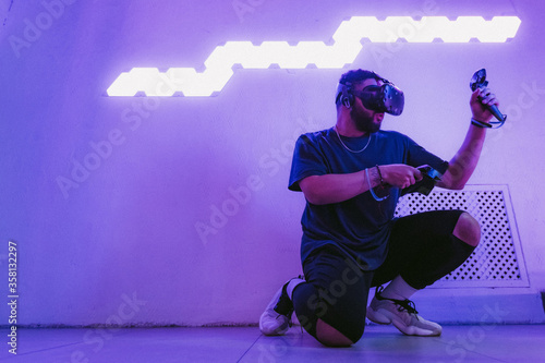 The guy is sitting in virtual reality. Neon retro style. The photo shows the effect of grain, noise.