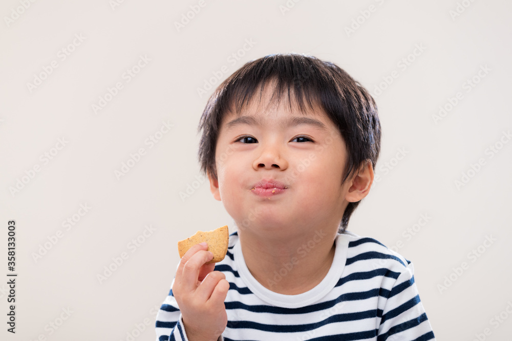 Little boy eat cookie on white background Little boy eat cookie on white background