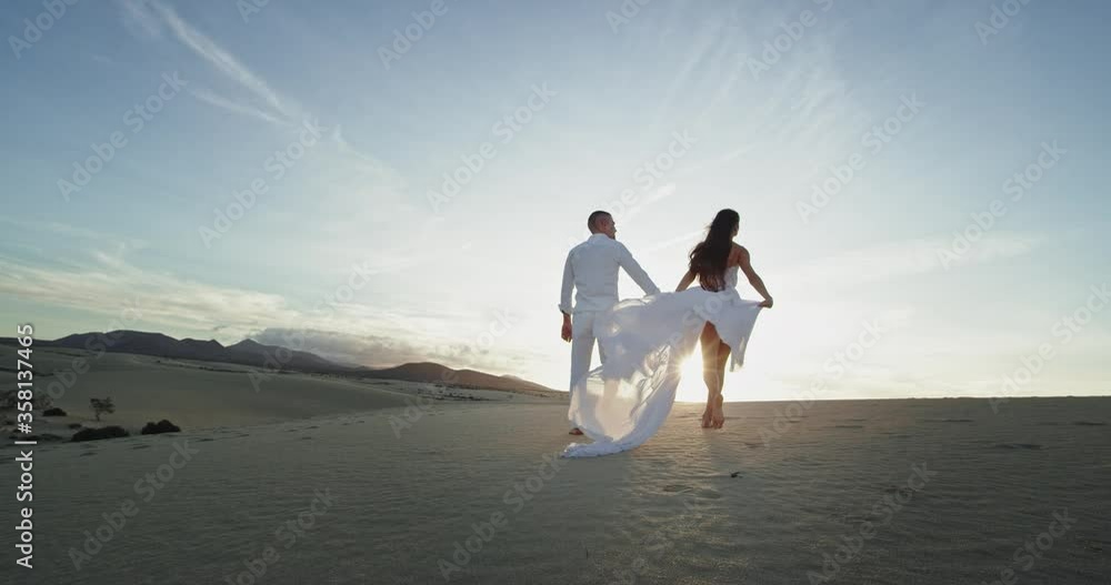 In a summer day romantic and sexy couple walking in front of the camera holding long dress they feeling very relaxed In a summer day romantic and sexy couple walking in front of the camera holding long dress they feeling very relaxed