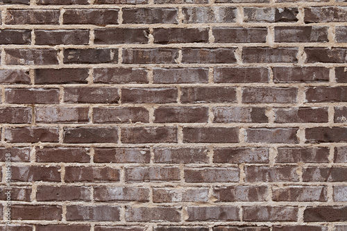 Close view of rough brown brick wall with sloppy extruded mortar finish, creative copy space, horizontal aspect