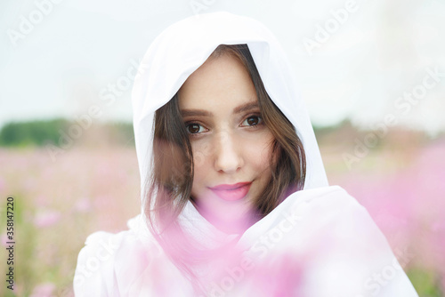 Beautiful girl in a field of lilac flowers.
