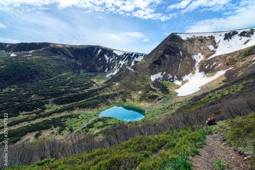 Lake in the mountains, the Ukrainian Carpathians, Lake Vorozheska, green slopes, sunbeams, a blue lake high in the mountains photo