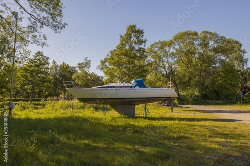 View of motor boat on parking holder on lake coast landscape view. Beautiful green nature view on background. Sweden. Europe.