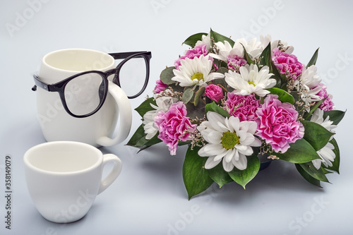 Celebration background for happy father's day. Creative breakfast with funny face made from a cups of coffee and glasses. Flowers for dad.