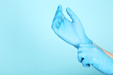 Doctor hands in gloves on blue background