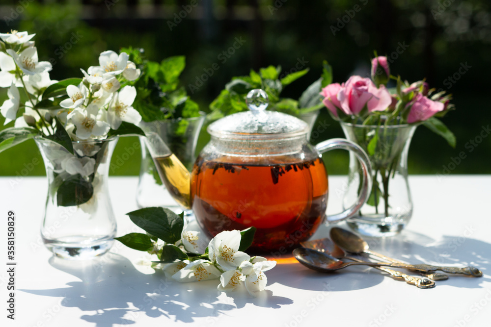 Flowers of rose, jasmine and mint leaves are in a Turkish glass mugs. Ingredients for Herbal Tea. Flowers of rose, jasmine and mint leaves are in a Turkish glass mugs. Ingredients for Herbal Tea.