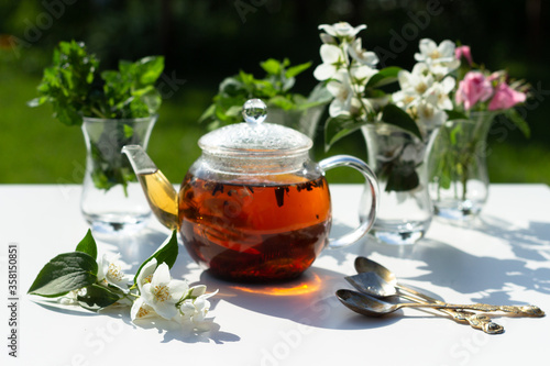 Flowers of rose, jasmine and mint leaves are in a Turkish glass mugs. Ingredients for Herbal Tea.