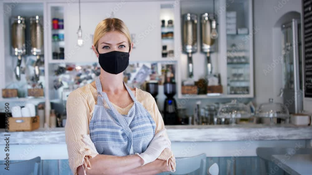 Woman owner with face mask in coffee shop, lockdown and back to normal concept. Woman owner with face mask in coffee shop, lockdown and back to normal concept.