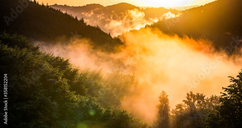 epic summer panorama of foggy sunset in mountains photo