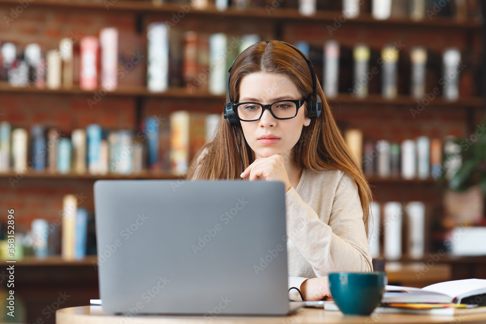 oung woman in headphones watching studying videos oung woman in headphones watching studying videos