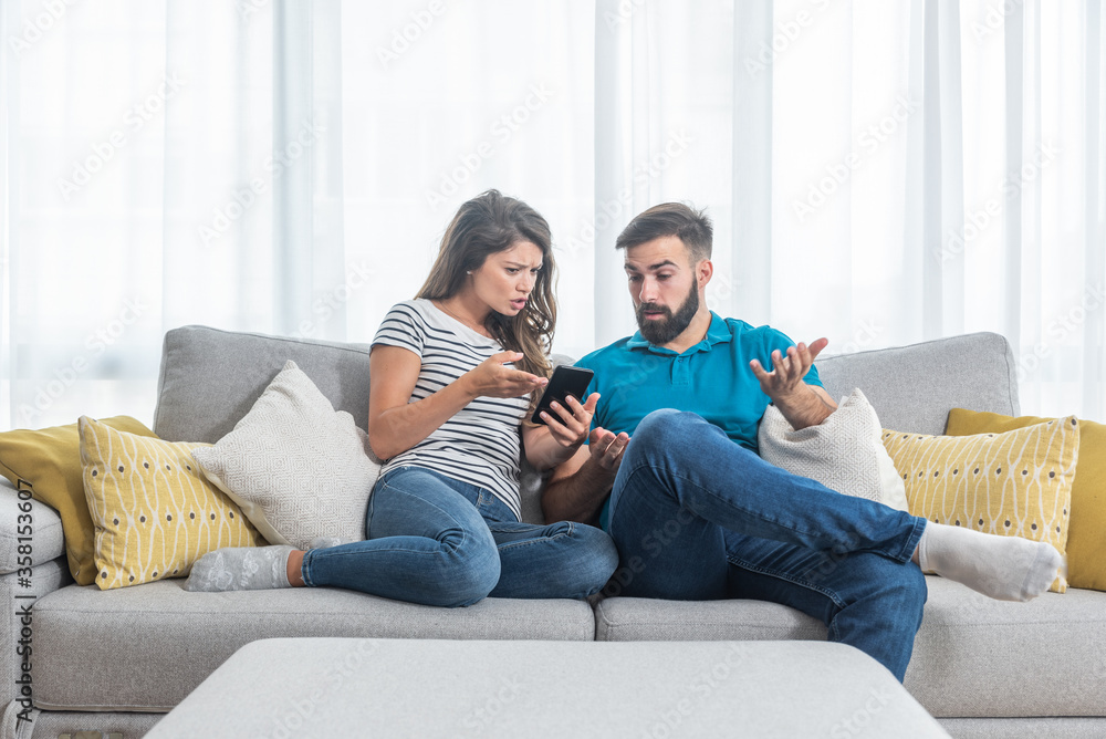 Young couple arguing about text messages on the boyfriends phone where girlfriend is jealous for finding the communication with other girl Young couple arguing about text messages on the boyfriends phone where girlfriend is jealous for finding the communication with other girl