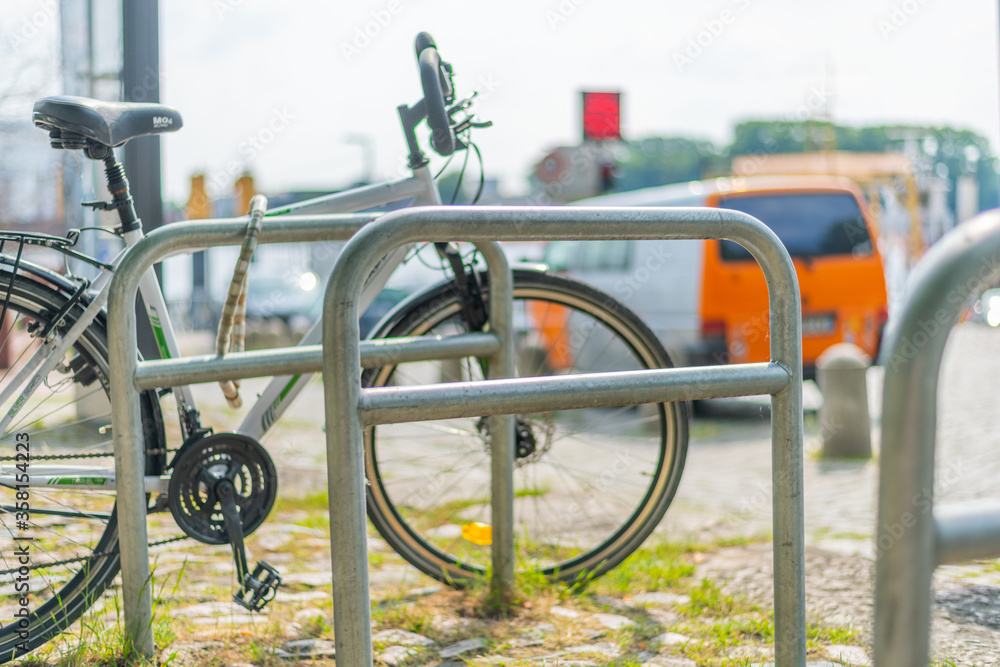 Mounts for bicycles in a pedestrian  area with a bicycle in the background