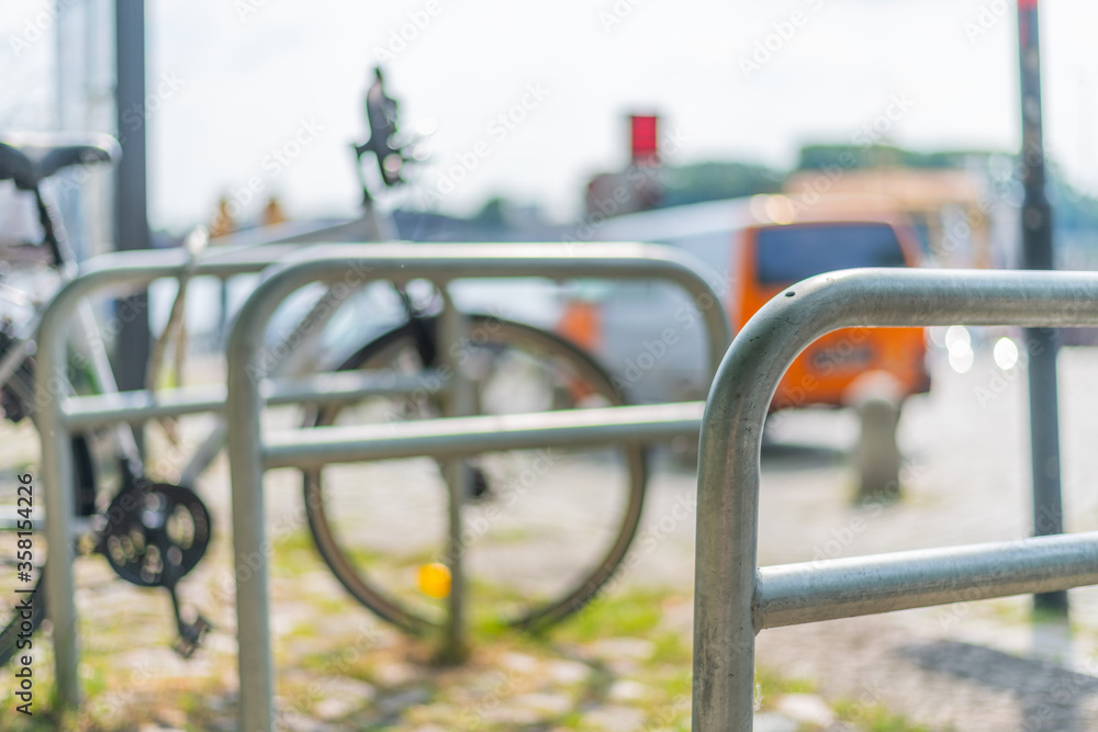 Mounts for bicycles in a pedestrian  area with a bicycle in the background