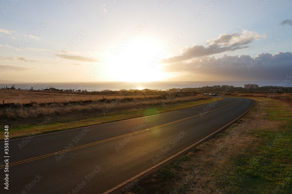 Sunset view from the Kaanapali hillside, road leading down to the beach