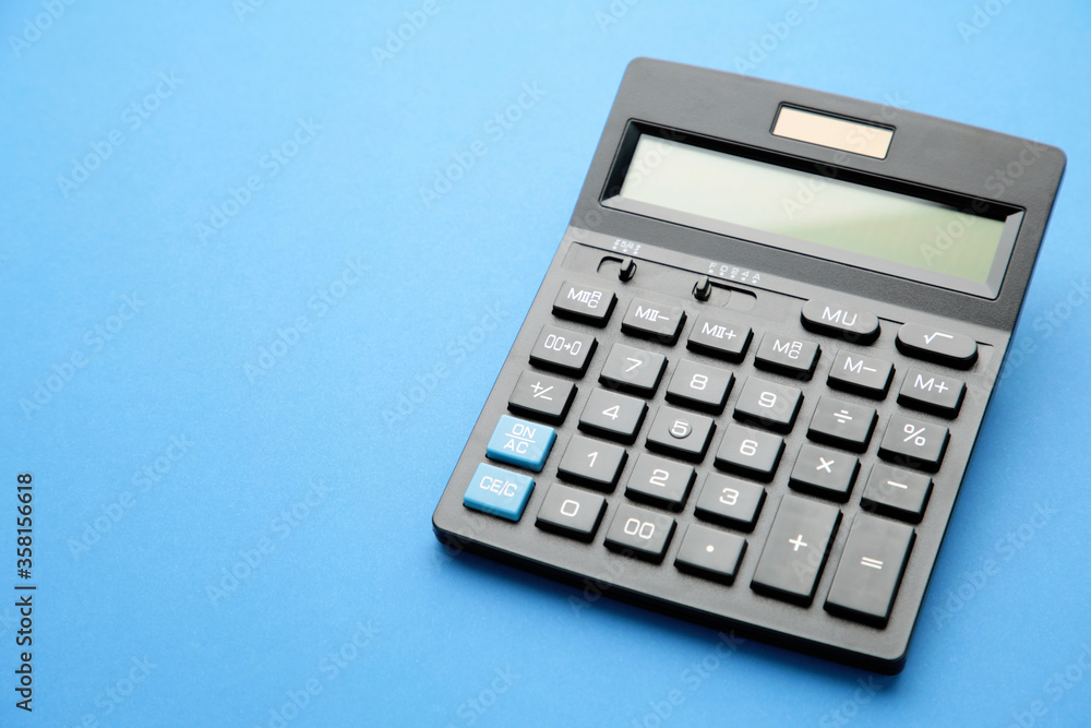Calculator on blue background with copy space Calculator on blue background with copy space