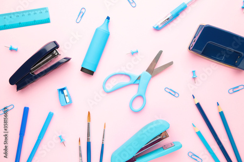 Blue school supplies on pink background. Back to school. Flat lay.