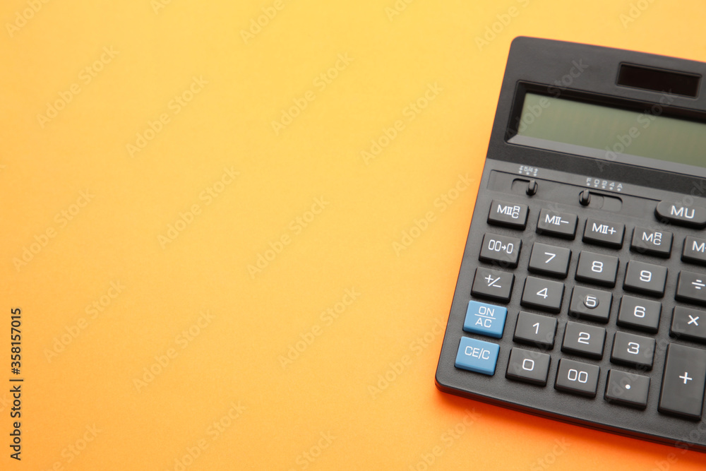 Calculator on orange background with copy space Calculator on orange background with copy space