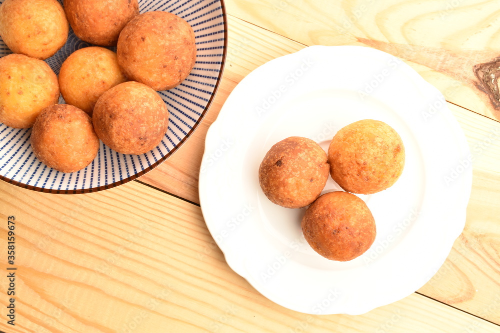 Fresh aromatic, cheese donuts, close-up, on a ceramic plate, on a wooden table. Fresh aromatic, cheese donuts, close-up, on a ceramic plate, on a wooden table.