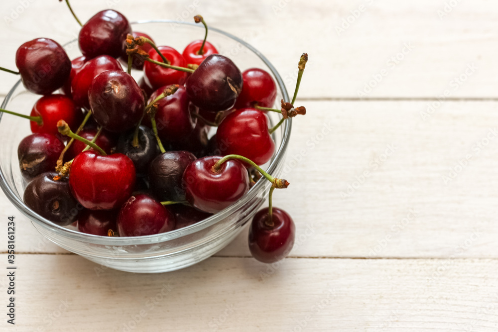 Sweet cherry lies in a bowl on the table. Cherry is a tasty and healthy berry. Sweet cherry lies in a bowl on the table. Cherry is a tasty and healthy berry.