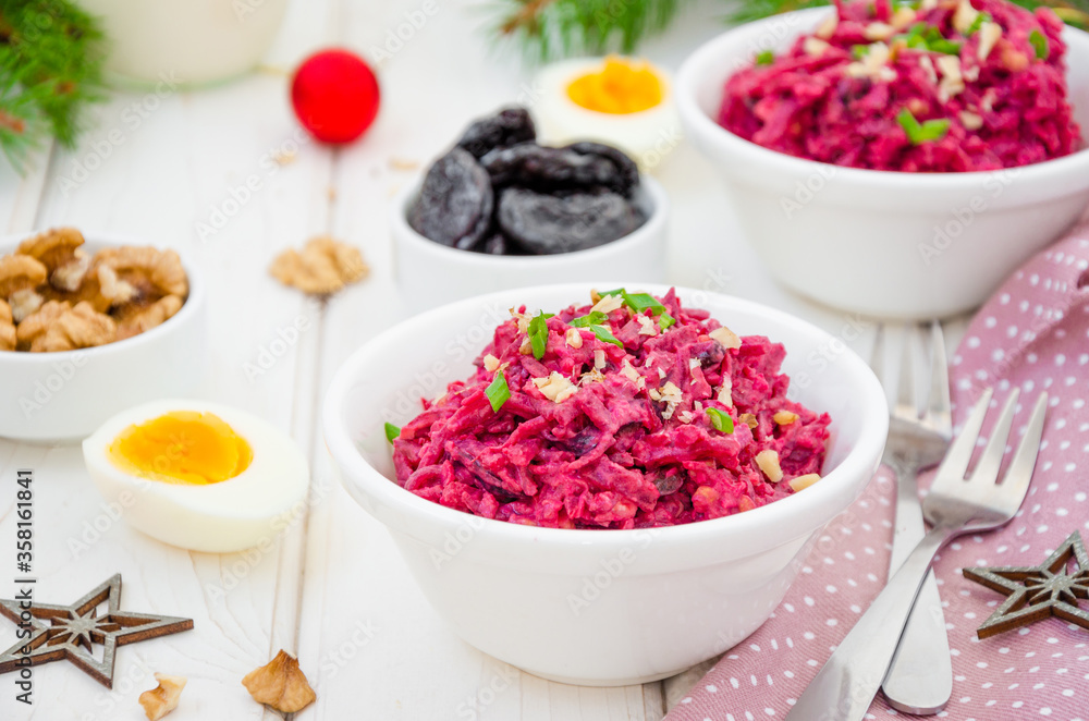 Salad of boiled beet. Beetroot salad with prunes, walnuts, eggs and sour cream in a bowl on white background. Healthy food. Salad for Christmas and New Year. Horizontal orientation. Close up Salad of boiled beet. Beetroot salad with prunes, walnuts, eggs and sour cream in a bowl on white background. Healthy food. Salad for Christmas and New Year. Horizontal orientation. Close up