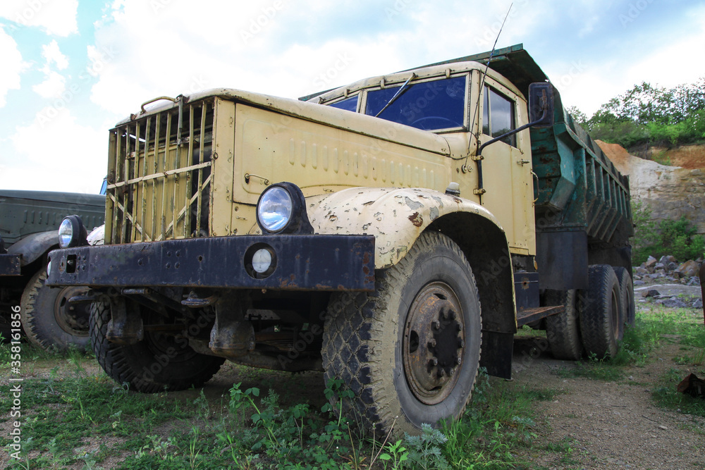 Obraz premium Old truck in very poor condition. A car stands in nature like abandoned metal rubbish. Stock photo background for design.