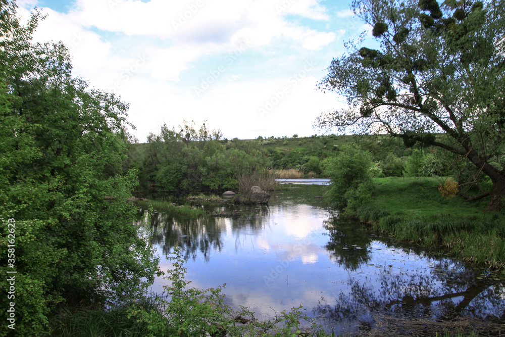 Beautiful river in the highlands in summer. Lake in an ecologically clean park reserve on a background of hills. A pretty landscape in the spring. Stock photo for design Beautiful river in the highlands in summer. Lake in an ecologically clean park reserve on a background of hills. A pretty landscape in the spring. Stock photo for design