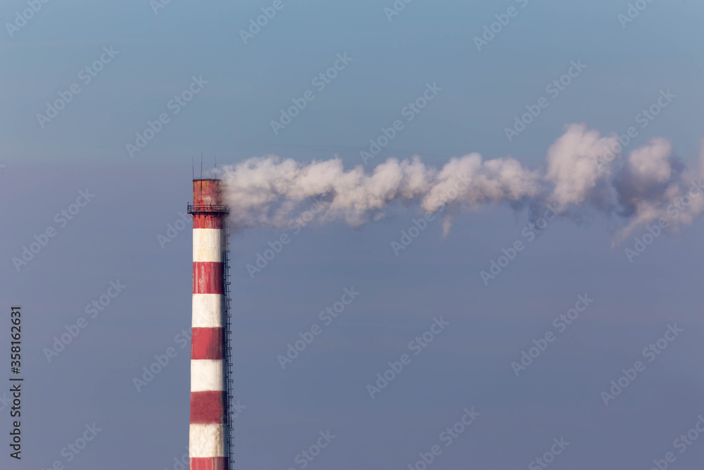 chimney with smoke on the background of the blue sky chimney with smoke on the background of the blue sky