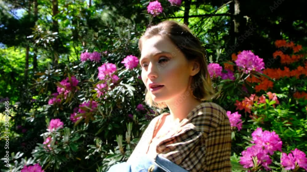 Young Girl Smiling Next to Flowers. Young Girl Smiling Next to Flowers.