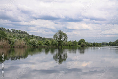 Beautiful river in the highlands in summer. Lake in an ecologically clean park reserve on a background of hills. A pretty landscape in the spring. Stock photo for design