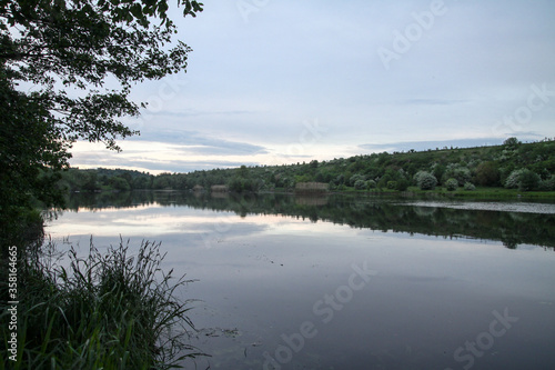 Beautiful river in the highlands in summer. Lake in an ecologically clean park reserve on a background of hills. A pretty landscape in the spring. Stock photo for design