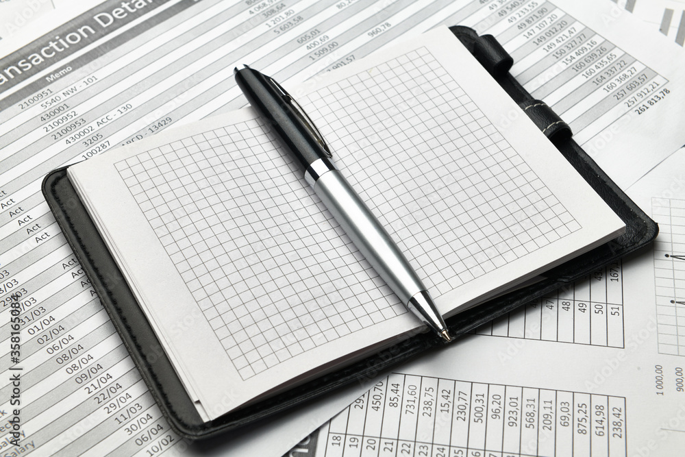 Top view of office employee's desk - empty Notepad with blank pages and financial reports, analysis and accounting Top view of office employee's desk - empty Notepad with blank pages and financial reports, analysis and accounting