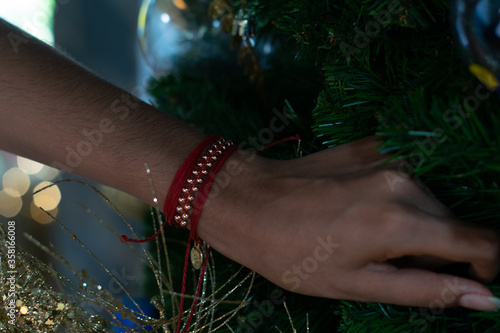 woman's hands with bracelets arranging the christmas tree