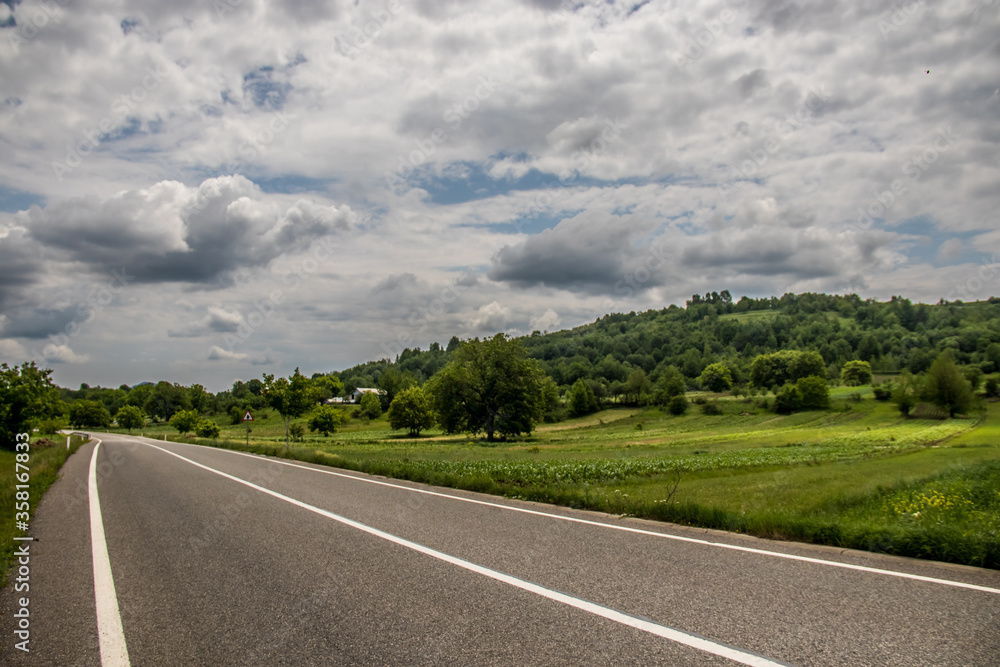 Asphalt road in countryside on sunny summer day in Vrancea region, Barsesti, Romania