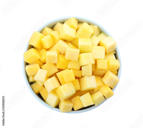 Tasty mango cubes in ceramic bowl isolated on white, top view