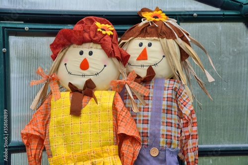 2 amusing scarecrows 'taking a break'  in a greenhouse.