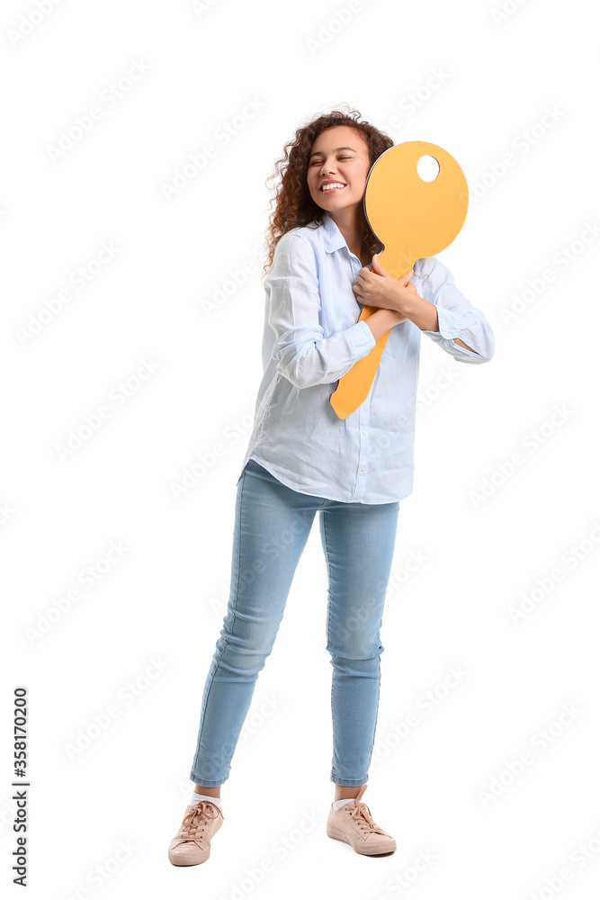 Happy young woman with big paper key on white background Happy young woman with big paper key on white background
